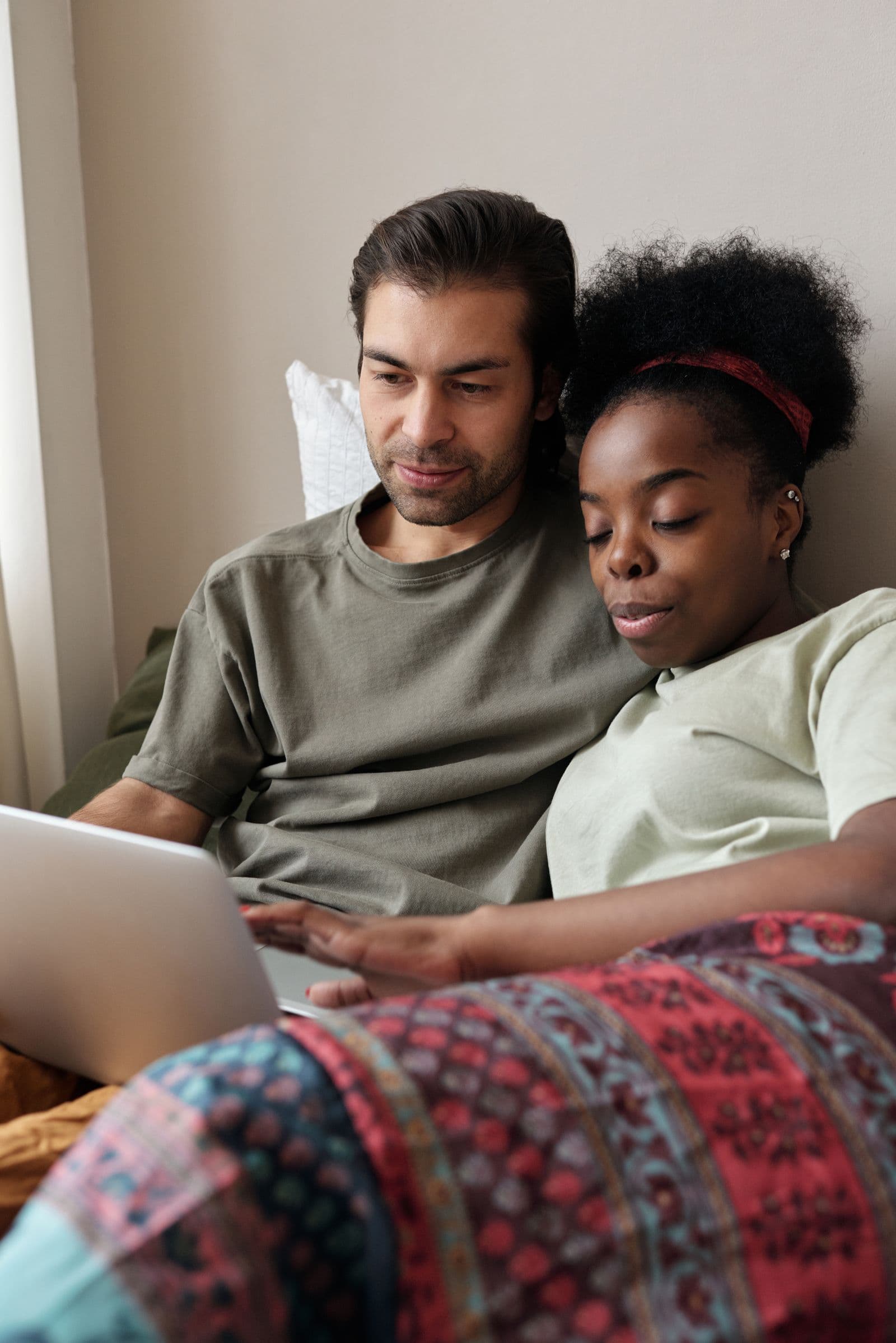 Household using a laptop near a home Wi-Fi router while comparing 5G and NBN internet.