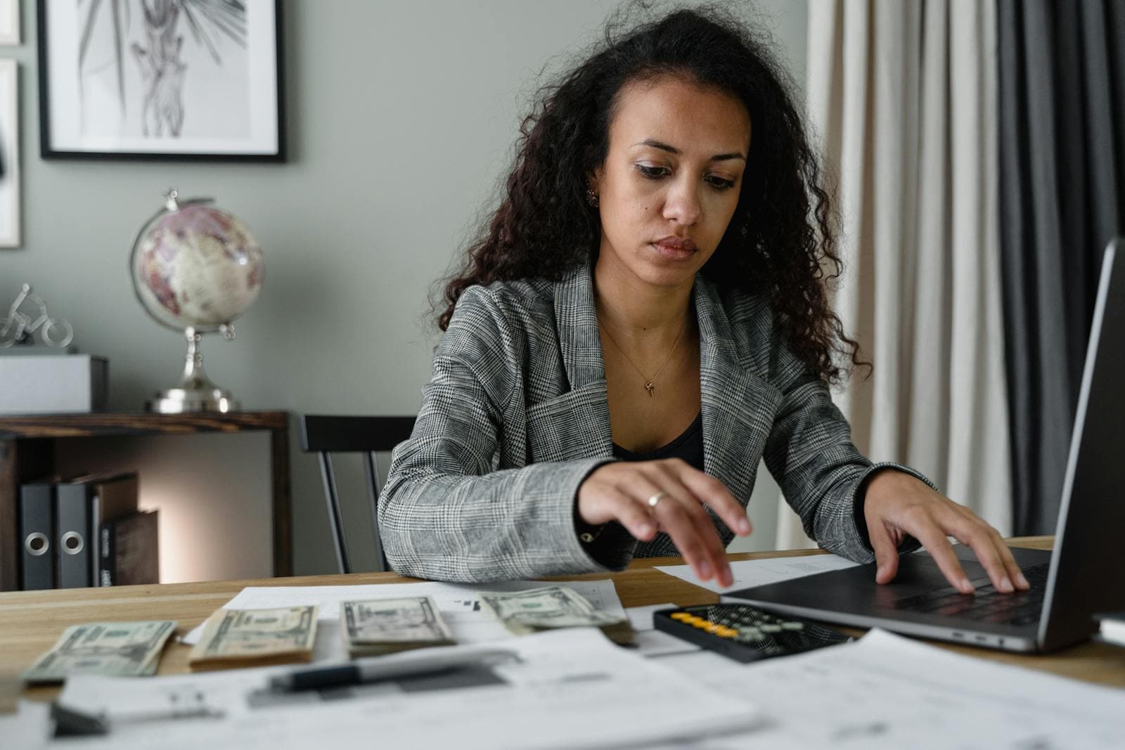 Compare GloBird Energy business electricity rates and plans comparison guide shown on a laptop beside printed utility bills